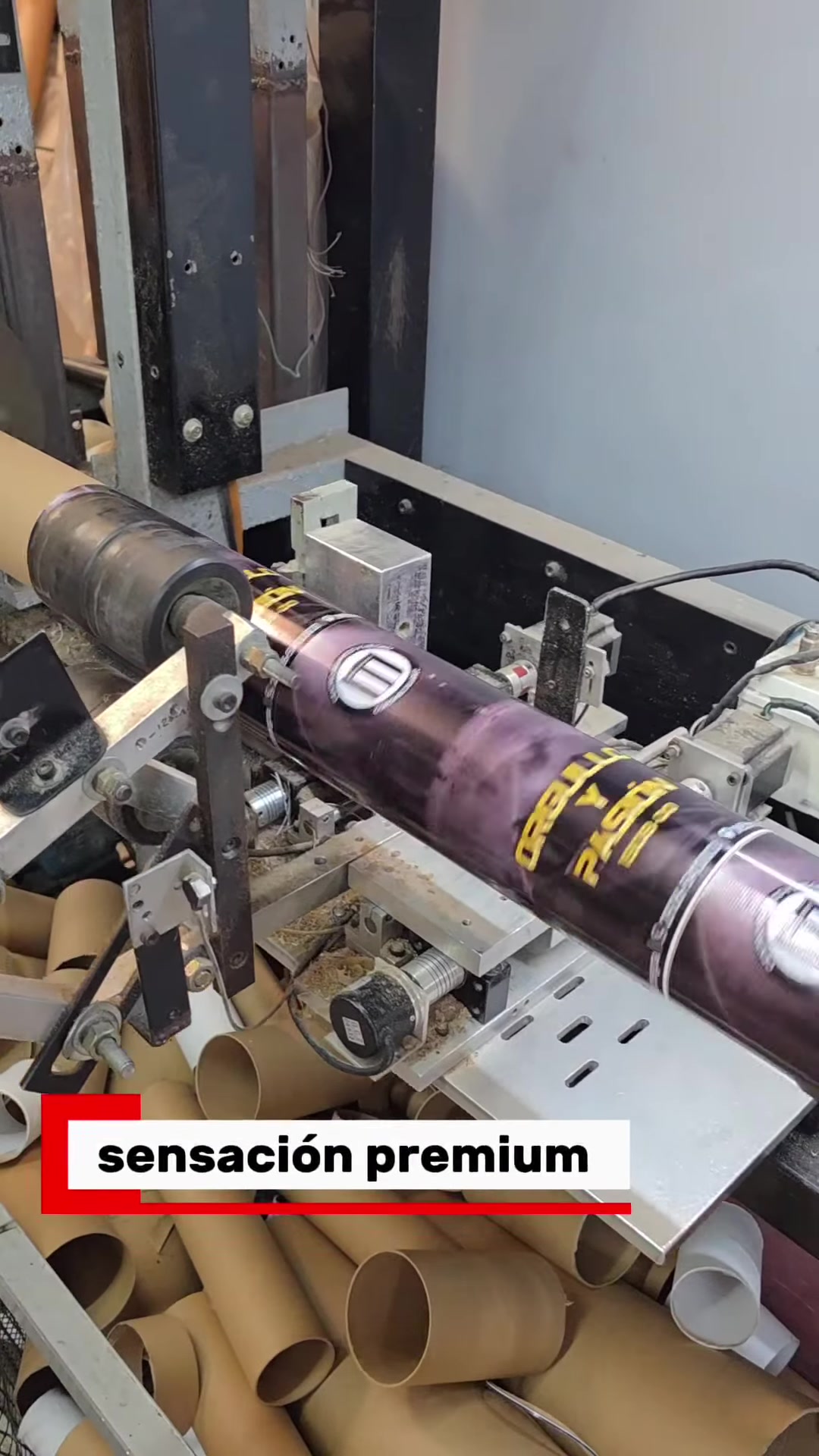 Tubo de cartón ploteado en una máquina de DG Embalajes, con tramos cortados debajo