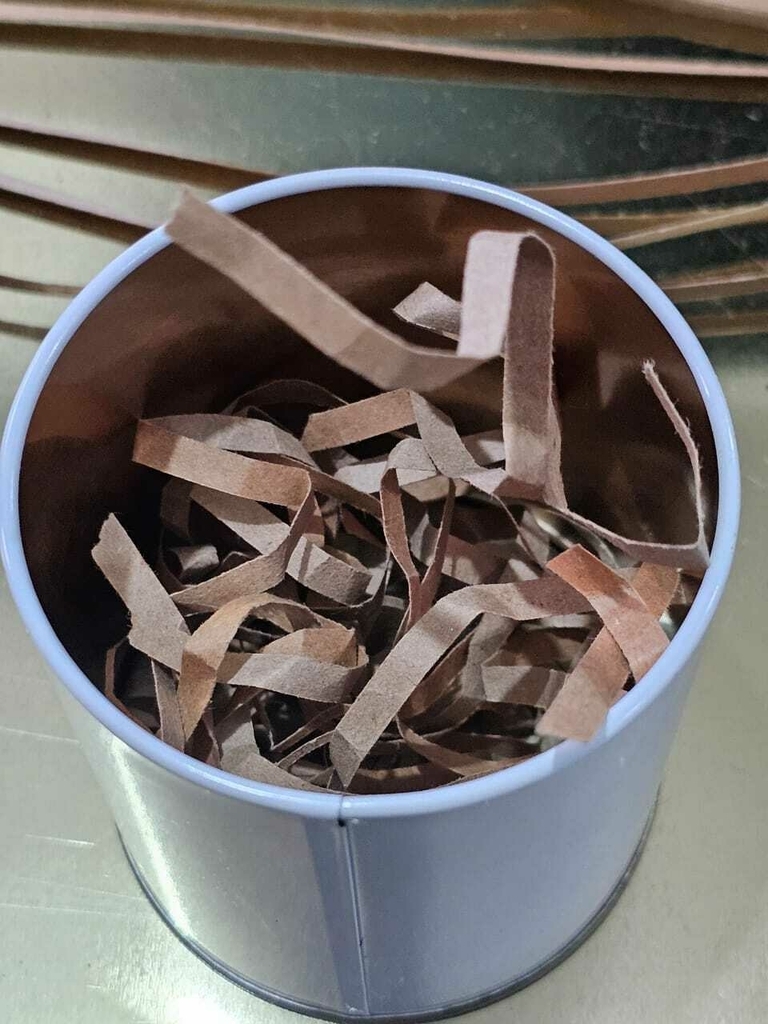 Viruta de cartón marrón utilizada como relleno dentro de un envase DG